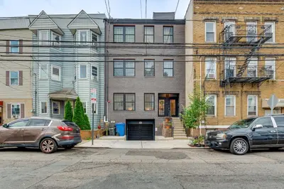 two cars parked in front of a building at Walk to Journal Square Modern Apt about 4 Mi to NYC! in Jersey City