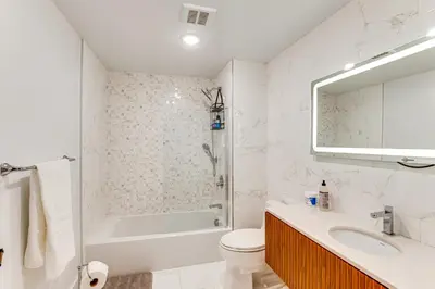 a bathroom with a tub and a toilet and a sink at Walk to Journal Square Modern Apt about 4 Mi to NYC! in Jersey City