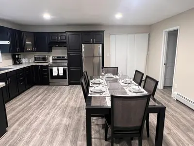 a kitchen with a dining room table with black cabinets at Peaceful home in mount bethel, PA in Mount Bethel