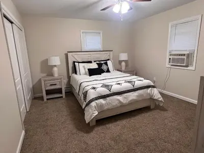 a bedroom with a bed with two night stands and two windows at Peaceful home in mount bethel, PA in Mount Bethel