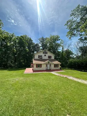 a house on a lawn with the sun in the sky at Peaceful home in mount bethel, PA in Mount Bethel
