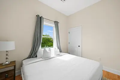 a bedroom with a large white bed with a window at Skyline Serenity Luxe NYC Retreat in Jersey City