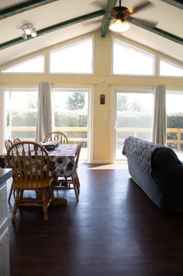 a living room with a table and chairs and a couch at Fenced Yard Chalets from Good Dog Vacations at Big Valley Resort in Sciota