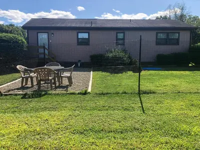 a fence with a table and chairs in a yard at Fenced Yard Chalets from Good Dog Vacations at Big Valley Resort in Sciota