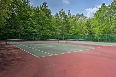 a tennis court with two tennis rackets on it at Pocono Lake House Beach, AC in Locust Lakes Village