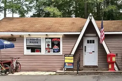 a small building with an american flag in front of it at Pocono Lake House Beach, AC in Locust Lakes Village