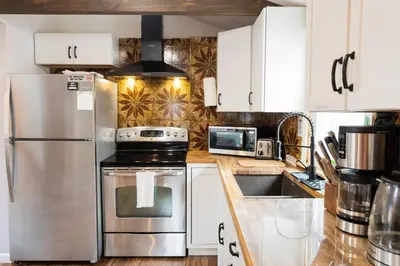 a kitchen with white cabinets and a stainless steel refrigerator at Pocono Lake House Beach, AC in Locust Lakes Village