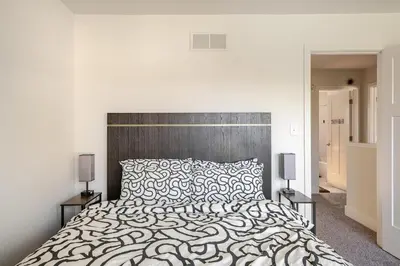 a white bedroom with a large bed and two lamps at Perfect Family Getaway! Steps from Attractions in Hummelstown