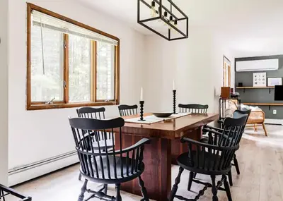 a dining room with a wooden table and black chairs at Eldred Manor in Eldred