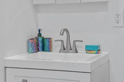 a kitchen sink with two toothbrushes and a faucet at Hoboken Hideaway - Walk to Transit - 15 Mins to NYC in Hoboken