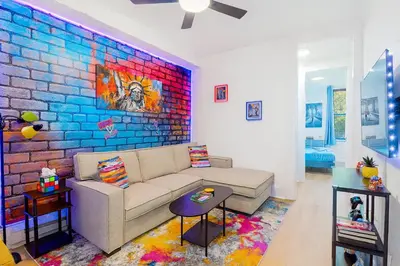 a living room with a couch and a brick wall at Hoboken Hideaway - Walk to Transit - 15 Mins to NYC in Hoboken