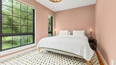 a bedroom with a large bed and two windows at Modern Chic Fishtown-Philly Home with Roof Deck in Philadelphia