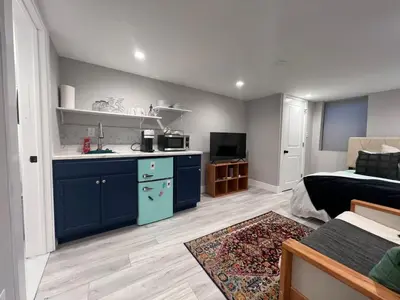 a kitchen with a blue island in a living room at Modern Chic Fishtown-Philly Home with Roof Deck in Philadelphia