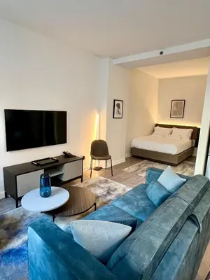a living room with a blue couch and a bed at One Dutch Hotel in New York
