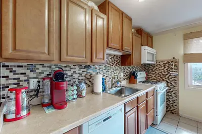 a kitchen with wooden cabinets and a counter top at Work and Play! Home 1 Mi to Dtwn and Central Market in York