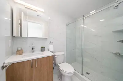 a bathroom with a toilet and a glass shower at Cozy apt with City skyline rooftop in Union City