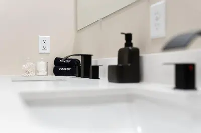 a bathroom counter with a bottle of water on it at Hip Dtwn Apt With Arcade And Gym in Binghamton