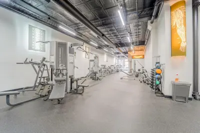 a gym with treadmills and machines in a room at Hip Dtwn Apt With Arcade And Gym in Binghamton