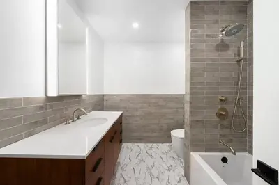 a bathroom with a sink and a toilet and a shower at Harlington by Rove Travel Private Backyard & Roof in New York