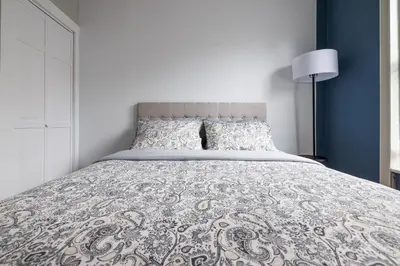 a bedroom with a large bed with a blue wall at Ultimate Urban living at Centrally Located Apartments in New York