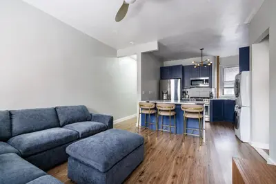 a living room with a couch and a kitchen at Ultimate Urban living at Centrally Located Apartments in New York