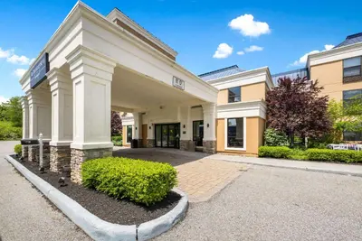 a large white building with bushes in front of it at The Crossroads Hotel - Newburgh in Newburgh