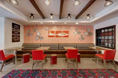 a restaurant with red chairs and a couch at The Crossroads Hotel - Newburgh in Newburgh