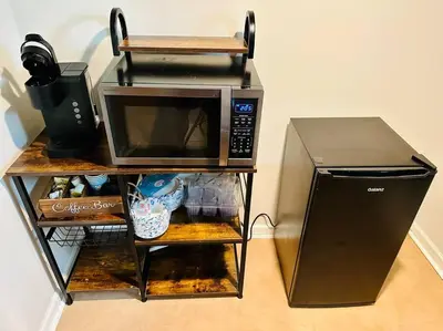 a microwave on a shelf next to a refrigerator at Campu Whole House in Cherry Hill