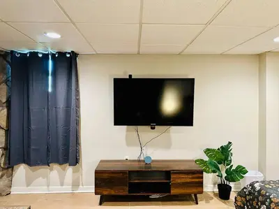 a flat screen tv on a wall in a living room at Campu Whole House in Cherry Hill