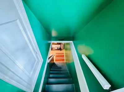 a staircase in a room with a green wall at Campu Whole House in Cherry Hill