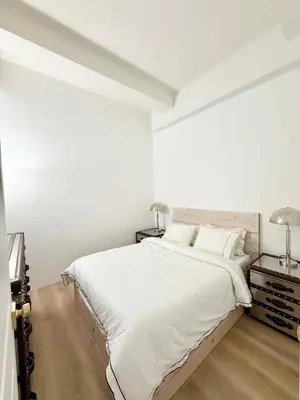 a white bedroom with a large bed and two lamps at GREAT APT 2 BED ROOM GREAT LOCATION nye in New York