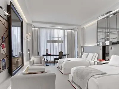 a hotel room with two beds and a desk at Baccarat Hotel and Residences New York in New York