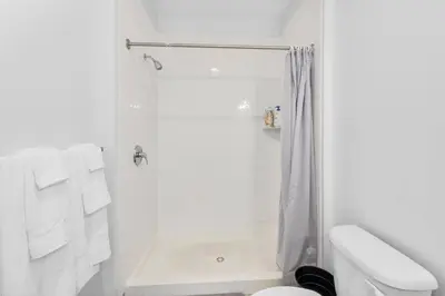 a white bathroom with a shower with white towels at Supreme 2 Bedroom Condo in Prime Jersey City in Jersey City