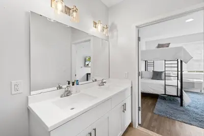 a white bathroom with two sinks and a mirror at Supreme 2 Bedroom Condo in Prime Jersey City in Jersey City