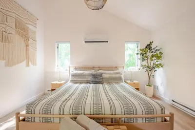 a bedroom with a large bed in a white room at Woodland Retreat in Blakeslee