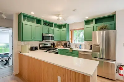 a kitchen with green cabinets and a refrigerator at Woodland Retreat in Blakeslee