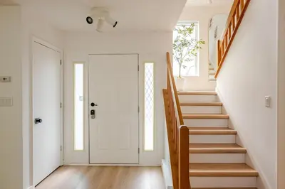 a staircase in a home with white walls and wooden floors at Woodland Retreat in Blakeslee