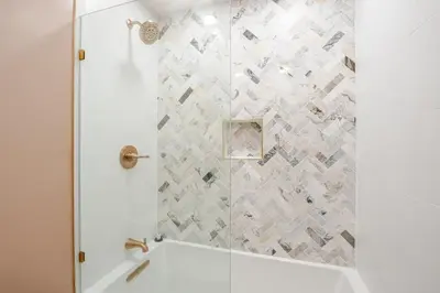 a bathroom with a shower with a white tub at Woodland Retreat in Blakeslee