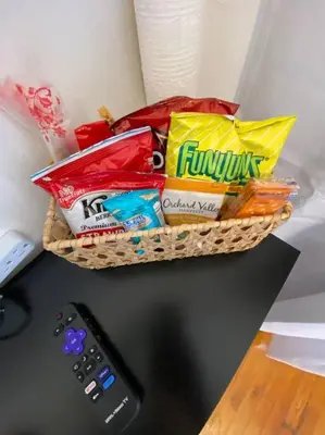 a basket of snacks on a desk next to a remote control at Apart Studio West NY 12Mints From NYCIty Times Square in West New York