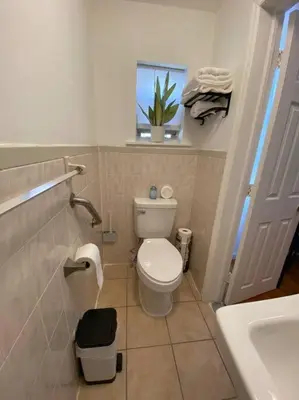 a bathroom with a toilet and a sink and a window at Apart Studio West NY 12Mints From NYCIty Times Square in West New York