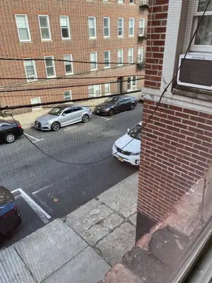 a view of a street with parked cars and a building at Apart Studio West NY 12Mints From NYCIty Times Square in West New York