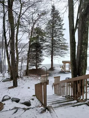 a snow covered park with two benches and a picnic table at Mountain Lake Retreat in Clifton