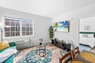 a living room with a bed and a table at Jersey City's Best Enjoy Our Deluxe 1 Bedroom Condo Only 25 Minutes to NYC in Jersey City