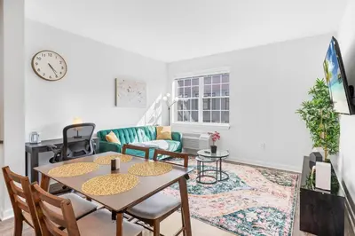 a living room with a table and chairs at Jersey City's Best Enjoy Our Deluxe 1 Bedroom Condo Only 25 Minutes to NYC in Jersey City