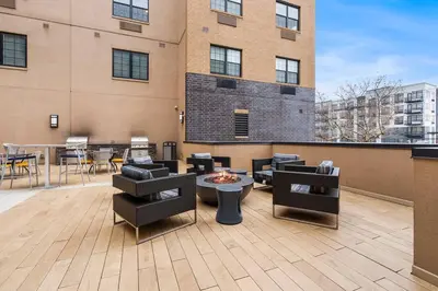 a rooftop patio with chairs and a fire pit on a building at Luxury Living in Jersey City Only Steps Away from Manhattan in Jersey City
