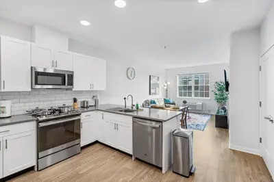 a kitchen with white cabinets and stainless steel appliances at Luxury Living in Jersey City Only Steps Away from Manhattan in Jersey City