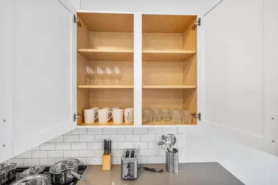 a kitchen with white cabinets and a counter top at Luxury Living in Jersey City Only Steps Away from Manhattan in Jersey City