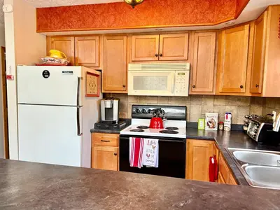 a kitchen with a white refrigerator and a stove top oven at WOW!! Ultimate Pocono Retreat Hot Tub, Game Room, Fire Pit, Near Lakes & Hiking! in Blakeslee