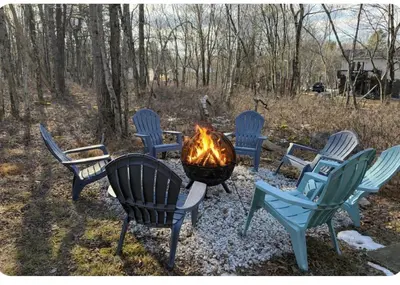 a group of chairs around a fire pit at WOW!! Ultimate Pocono Retreat Hot Tub, Game Room, Fire Pit, Near Lakes & Hiking! in Blakeslee