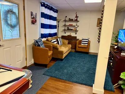 a living room with two couches and a blue rug at WOW!! Ultimate Pocono Retreat Hot Tub, Game Room, Fire Pit, Near Lakes & Hiking! in Blakeslee